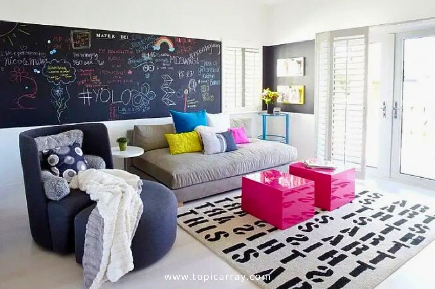 A modern living room featuring a large DIY chalkboard paint accent wall covered in colorful chalk drawings and text, providing a fun and interactive focal point.