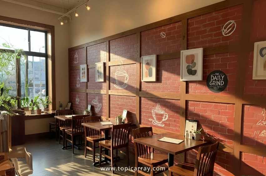 A DIY painted faux brick panel wall in a cafe setting, featuring stenciled brick texture and white hand-drawn graphics, adding texture without renovation costs.
